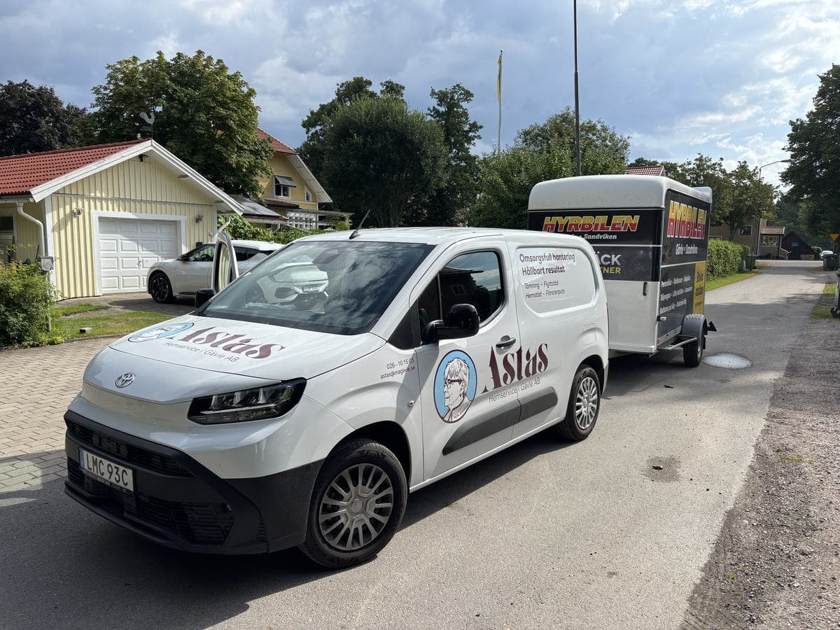 Astas arbetsbil med släp på en villagata